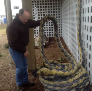 Mike Giles inspects the WWII-era line that the federation is inviting people to string recycled nautical items on as Christmas decorations. Photos: Skip Maloney