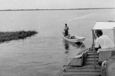 Henry Pigott poles out to greet the Aleta off Porstmouth Island in this circa 1953 photo. That's Capt. Elmo Fulcher at the helm. Photo:Friends of Portsmouth Island
