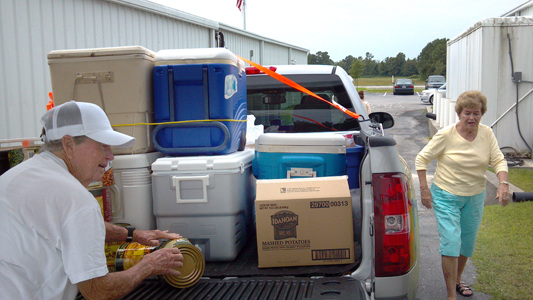 Amy Wetherington, left, and Sharon Johnson, members of Carteret-Craven Electric Cooperative, pile a truck high with coolers at A Second Helping – Emerald Isle. Photo: George Gardner