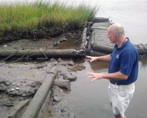 Jim McKee explores the eroded shoreline at the Brunswick Town Historic Site. Photo: State Port Pilot