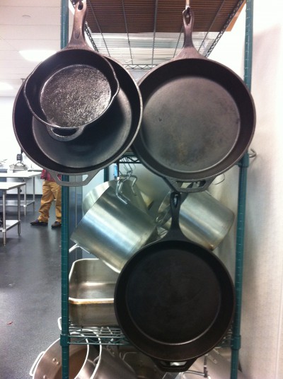 Still relevant: Cast-iron skillets hang among the more common stainless steel pans students use at The Chef's Academy, a culinary school in Morrisville, near Raleigh. Photo: Liz Biro