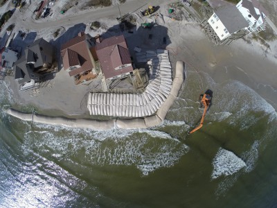 This picture taken in 2014 shows the sand bag wall being built. That long tube front the wall was supposed to be removed after construction. It wasn't and now lies mostly buried in the sand. Photo: North Topsail Beach