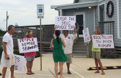 A small group of north Rodanthe property owners gather outside the Rodanthe-Waves-Salvo Community Building to protest NCDOT’s chosen alternative for bridging the S-curves and Mirlo beach. Photo: Island Free Press