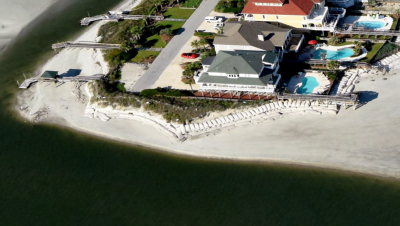The CRC waived the rules to the owners of this threatened house on Ocean Isle to build a bigger sandbag. Photo: N.C. Division of Coastal Management