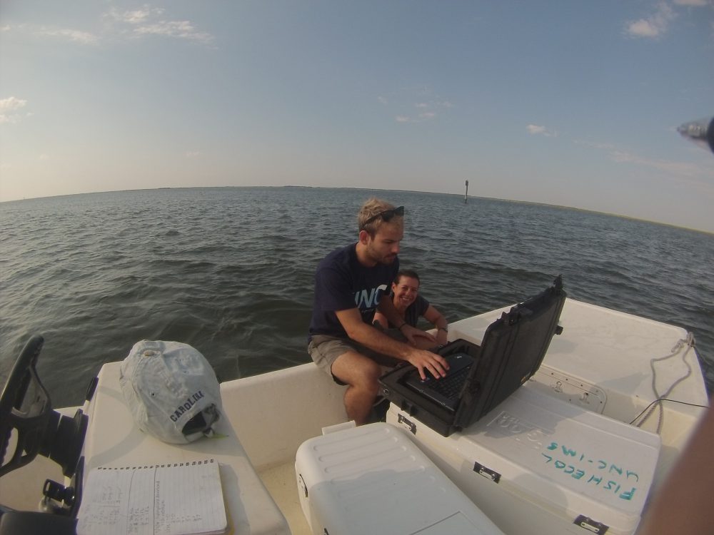 Danielle Keller and fellow doctoral student Ian Kroll check on data from hydrophones that tracktagged fish. Photo: Ashita Gona