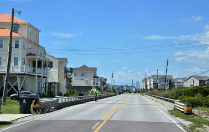 A bicyclist crosses a bridge built over one of the more than half-dozen spots in North Topsail Beach where Hurricane Fran cut channels that washed away the road and homes. Photo: Mark Hibbs