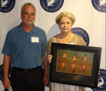 North Carolina Coastal Federation Director Todd Miller presents a 2016 Pelican Award on Aug. 6 to Jan Harris of Sunset Beach in recognition of her coastal advocacy. Photo: Sam Bland