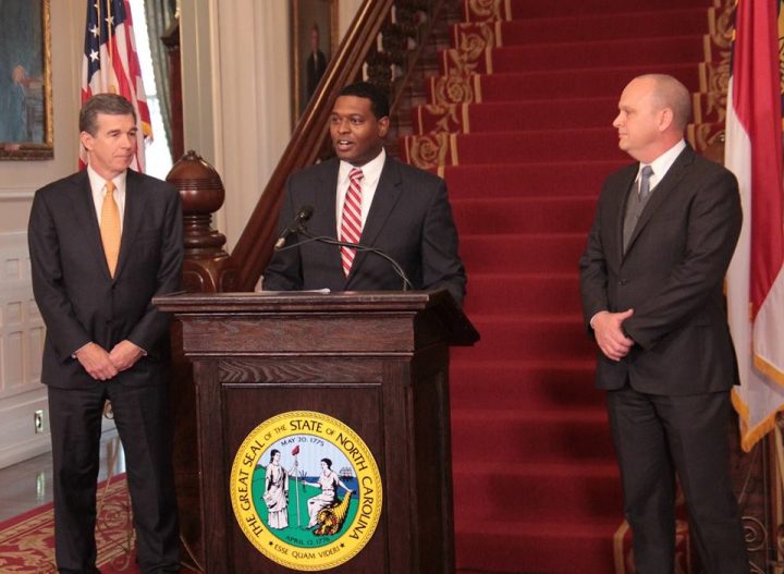 Michael Regan, Gov. Roy Cooper's pick to lead the Department of Environmental Quality, speaks Tuesday, flanked by Cooper, left, and newly named Transportation Secretary Jim Trogdon. Photo: Kirk Ross